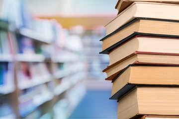Stack of colorful books on blurred background