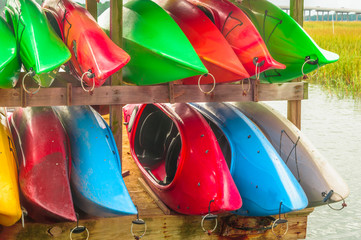 Colorful kayaks tied up on Hilton Head Island dock on water.