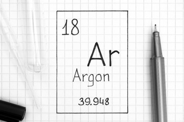 Handwriting chemical element Argon Ar with black pen, test tube and pipette.
