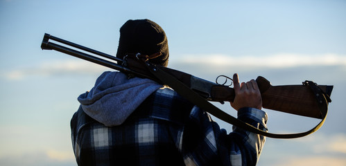 Brutality and masculinity. Hunter carry rifle gun on shoulder rear view. Guy hunter spend leisure...