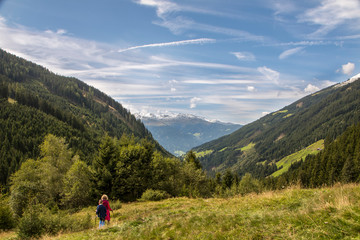 Fototapeta premium Woman standing on a footpath with a magnificent view - view from behind