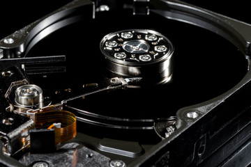 Disassembled and opened hard disk drive, inside view with reflections, isolated on black