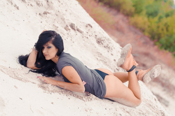 Beautiful sensual black haired woman  in safety boots on sand dunes