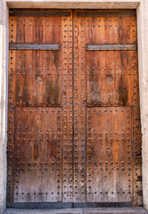 Medieval doors.  Spanish traditional ornament on wooden gates. Old wooden gate texture. Strong fortress, Spain.