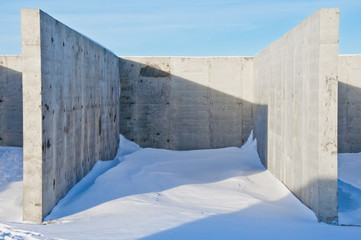 Concrete construction on the background of the winter landscape is covered with snow. Frosty sunny day.