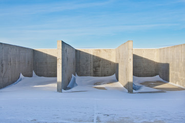 Concrete construction on the background of the winter landscape is covered with snow. Frosty sunny day.