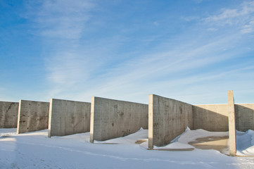 Concrete construction on the background of the winter landscape is covered with snow. Frosty sunny day.