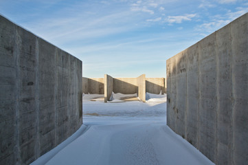 Concrete construction on the background of the winter landscape is covered with snow. Frosty sunny day.