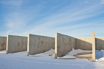 Concrete construction on the background of the winter landscape is covered with snow. Frosty sunny day.