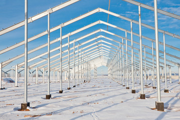 The structure of the building. Steel construction on the background of the winter landscape.