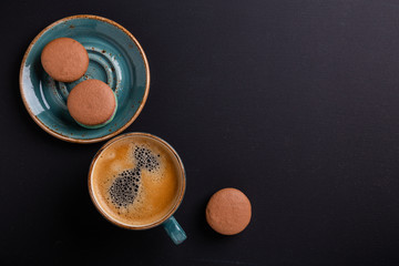 Blue cup of coffee and macaroons on the dark wooden table. Coffe break. Top view. Flat lay