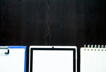 Tablet with notepad on dark background.
