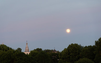 Gloomy landscape with crosses and birds around the moon