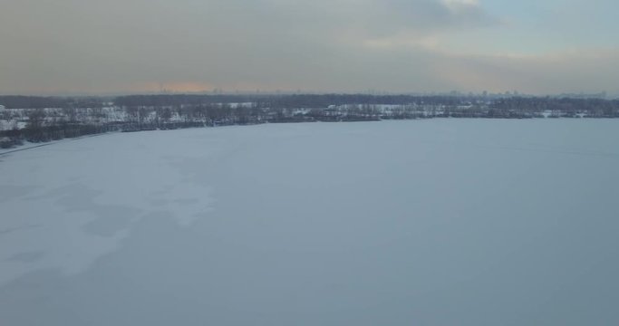 Drone shot of frozen river in forest.Frozen River Road In Rural Area.