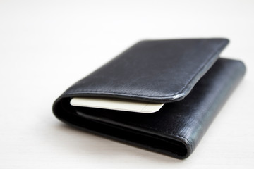 men's black wallet money in cash wooden white vintage background.