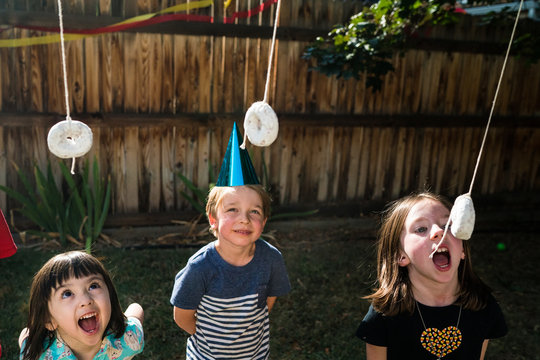 Children playing with donuts outdoors