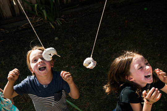 Children playing with donuts outdoors