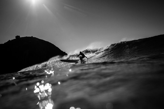 Surfer surfing in sea against sky