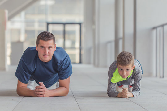 Little boy and his farher doing push ups together