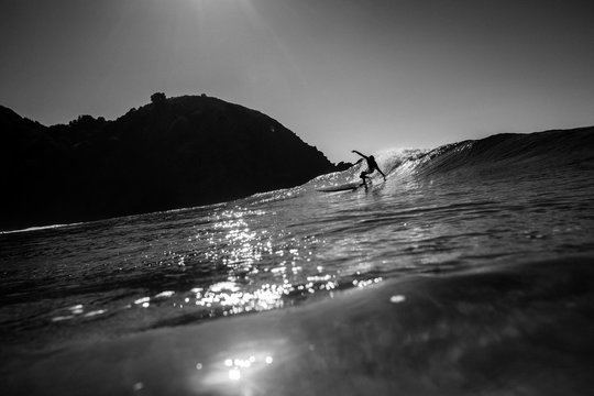 Surfer surfing in sea against sky