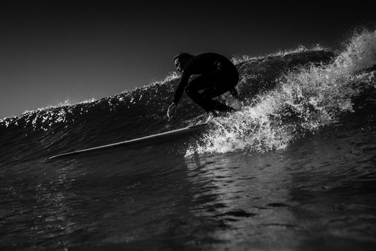 Surfer surfing in sea against sky
