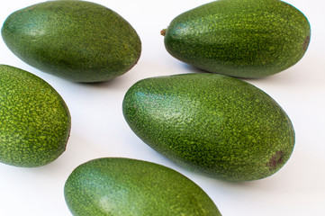 five fresh avocados on white background top side view