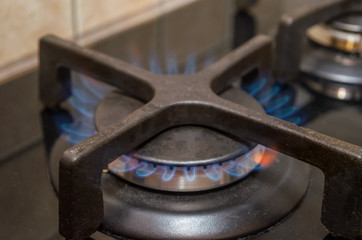 Modern kitchen stove cook with blue flames burning.