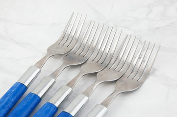 Five forks on white gray background.