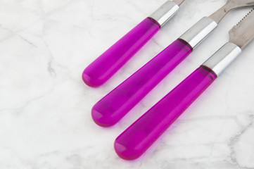 Two spoons and knife on white gray background.