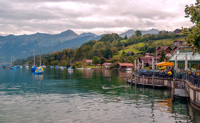 Fototapeta na wymiar SPIEZ, BERNE, SWITZERLAND-SEPTEMBER 2014, Lake in Switzerland with boats on a cloudy day with mountains in the background