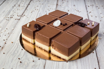 Dark chocolate vegan cake with candies on wooden background