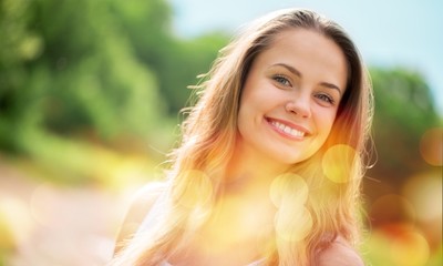 Naklejka premium Young woman on field under sunset light