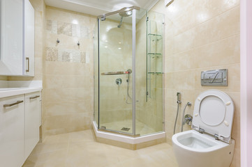 Bright bathroom interior with glass shower and toilet
