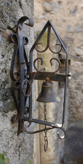una vecchia campana di ferro su un muro ormai arrugginita - 242746531