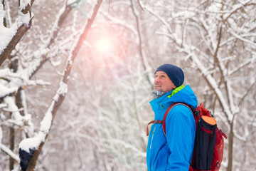 Fototapeta na wymiar Happy man, traveler walking in the winter forest