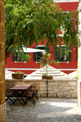 Naklejka na ściany i meble Charming cafe in a colorful narrow street in Sibenik, Croatia. Traditional Mediterranean architecture. Selctive focus.