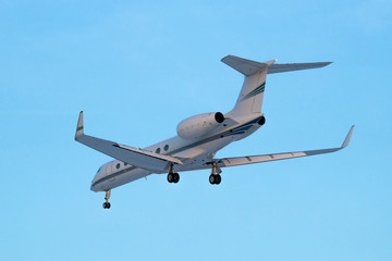 White modern business jet landing
