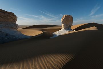Amazing sunset landscape showing white chalk limestone rock formations in the Egyptian White Desert...