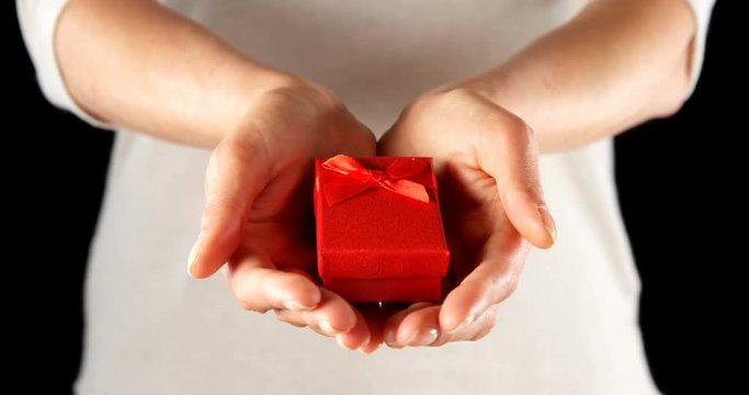 Close-up of hand holding small red gift box