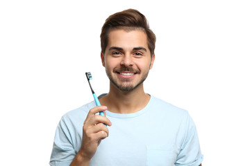Portrait of young man with toothbrush on white background