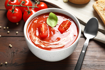 Bowl with fresh homemade tomato soup on wooden table