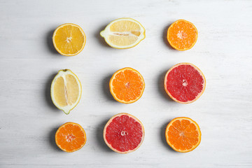 Different citrus fruits on wooden background, flat lay