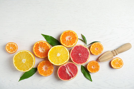 Different citrus fruits on wooden background, flat lay