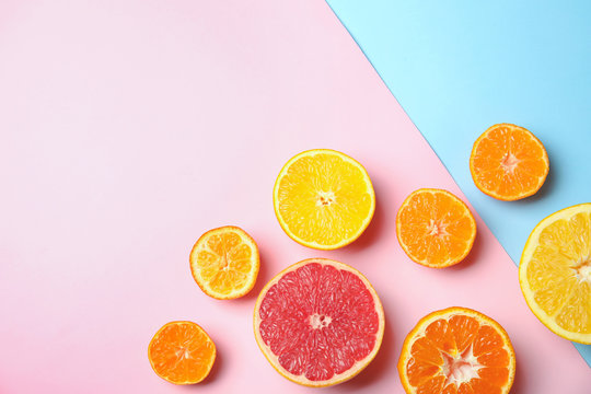 Different citrus fruits on color background, flat lay. Space for text