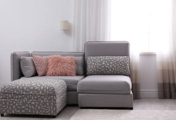 Modern living room interior with comfortable sofa near window
