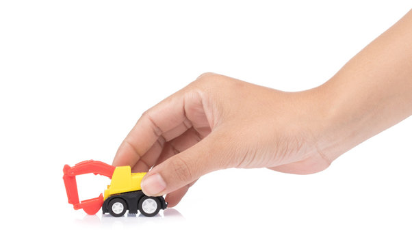 Hand Holding The Toy Tractor Isolated On A White Background.