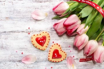 Valentines day background with homemade frosted  heart cookies and fresh tulips