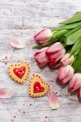 Valentines day background with homemade frosted  heart cookies and fresh tulips