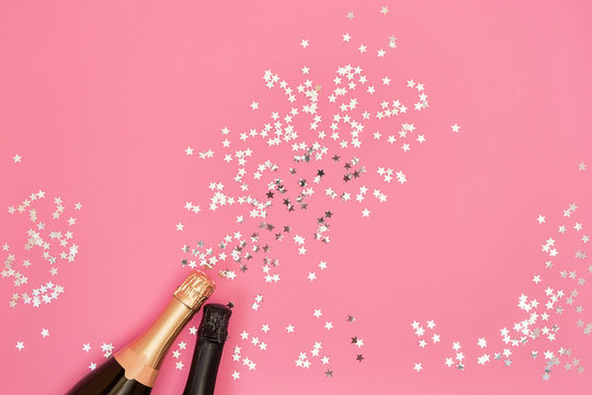 Champagne bottles with confetti stars on pink background. Copy space, top  view Stock Photo | Adobe Stock
