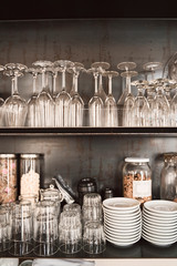 glasses and plates on the shelves of  a stylish modern restaurant. 
